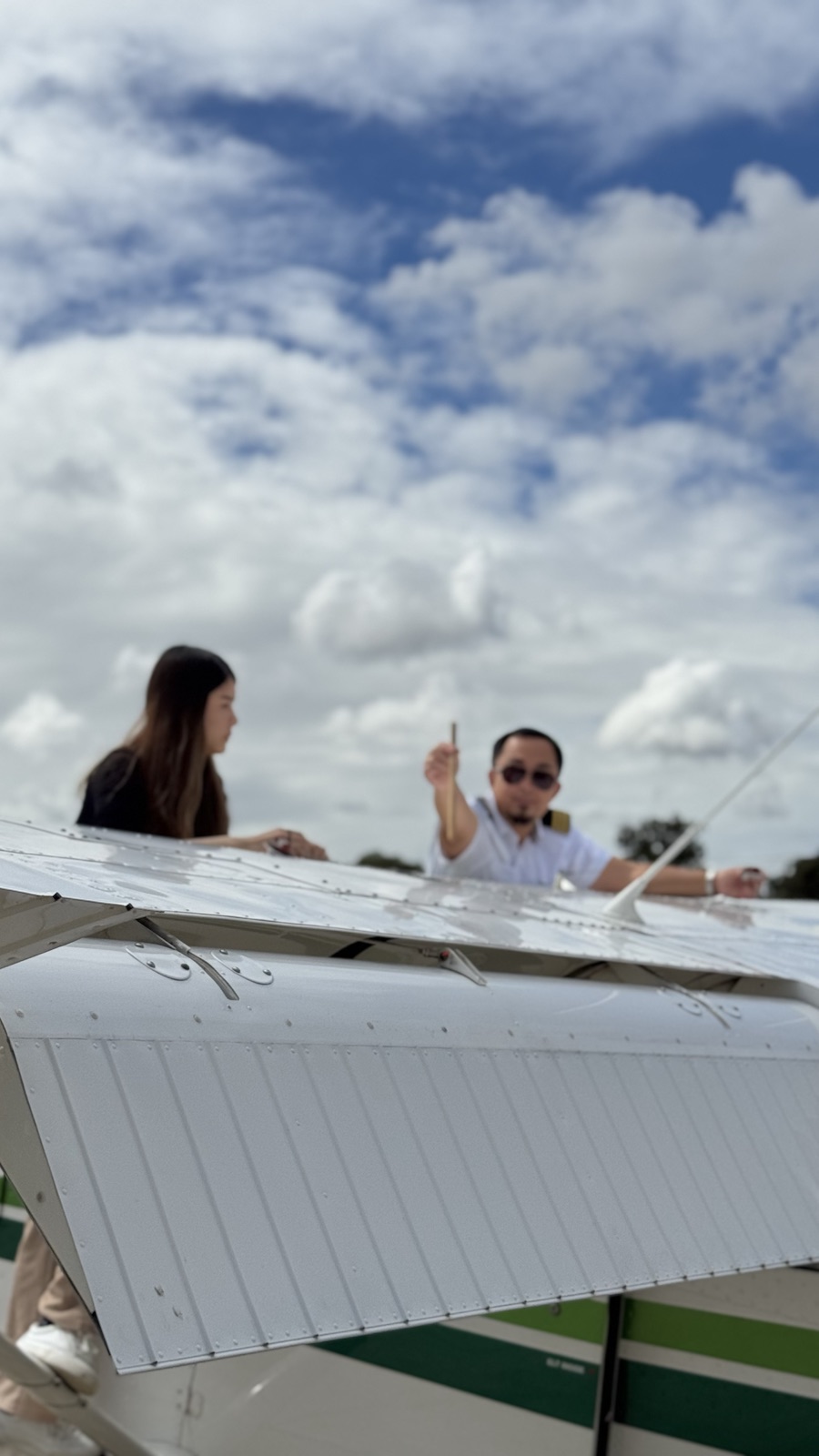 Instructor and student beside an aircraft wing