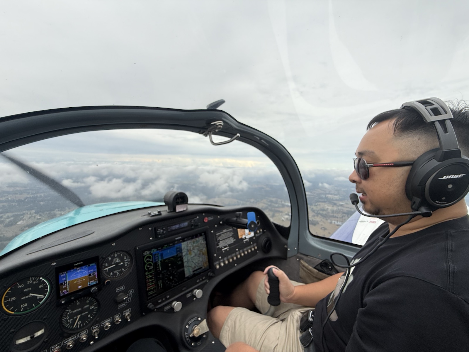 Pilot flying above clouds in a light aircraft cockpit