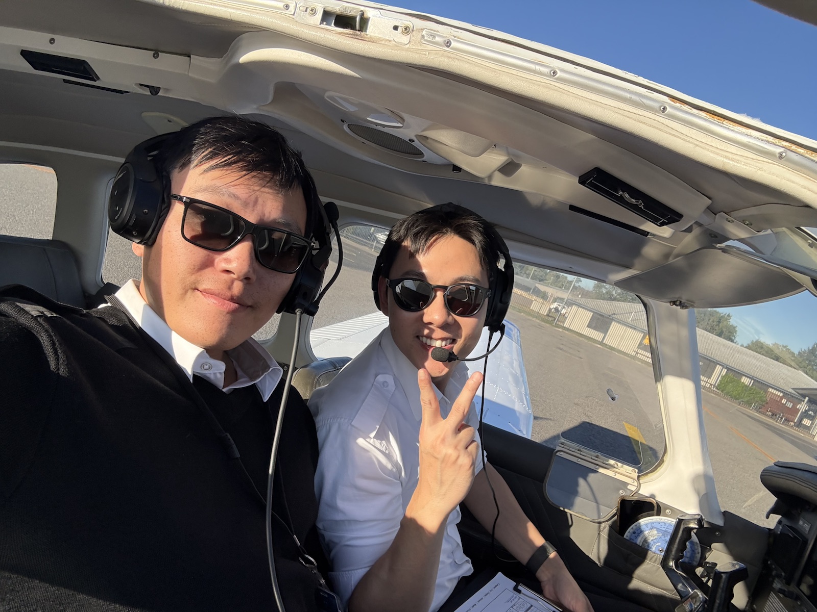 Instructor and student smiling inside a training aircraft